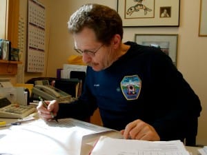 Dave Berg looks over a spread sheet of this year's visitors at Viking Travel, Inc. Photo/Angela Denning