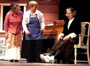 During rehearsal, Sneerella Twerm, played by Mary Ellen Anderson, tries on shoes at the shoe shop run by Agnes and Matilda (Irene Littleton and Cindy Marden). Photo/Angela Denning